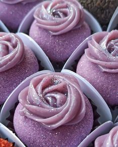 some cupcakes with purple frosting in a box