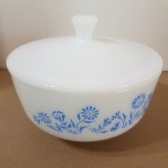 a blue and white bowl sitting on top of a brown table next to a wall