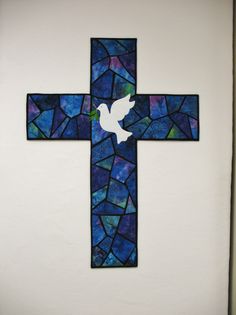 a stained glass cross with a dove on it