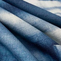 blue jeans with white stripes are stacked on top of each other in this close up photo