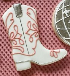 a cookie shaped like a cowboy boot with the word love written in pink on it