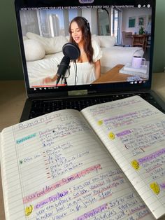 an open notebook sitting on top of a laptop computer