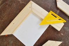 a pair of scissors and some wood pieces on the ground next to a piece of plywood