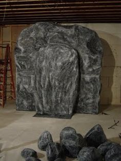 two large rocks sitting next to each other in front of a wall with ladders