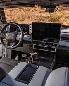 the interior of a vehicle with an entertainment center and laptop on the dash board in front of it