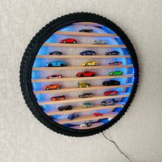 a clock made out of a tire with toy cars on the shelf in front of it