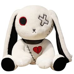 a white stuffed animal with red eyes and a cross on it's chest sitting in front of a white background