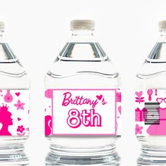 three water bottles with pink and white designs on them