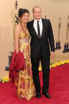 a man and woman standing next to each other on a red carpet