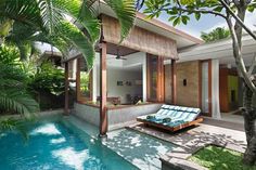 an outdoor swimming pool with chaise lounges next to it and palm trees in the background