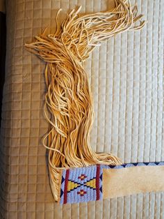 a piece of woven material is laying on top of a bed