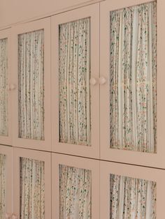 four white cabinets with floral curtains on the front and side panels, all lined up against each other