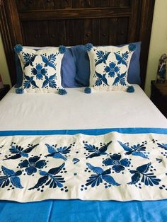 a bed with blue and white pillows on it