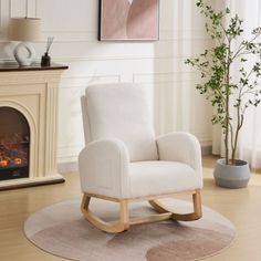 a white rocking chair sitting on top of a wooden floor next to a fire place