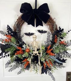 a wreath with a skeleton and flowers on it