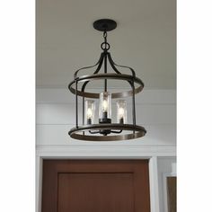 a chandelier with three lights hanging from it's center beam in front of a door