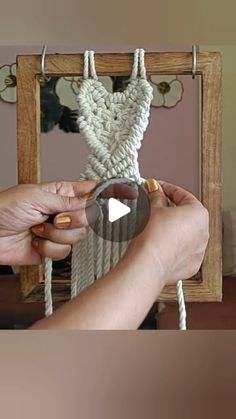 a woman is holding a piece of rope in front of a mirror that has a dress hanging on it