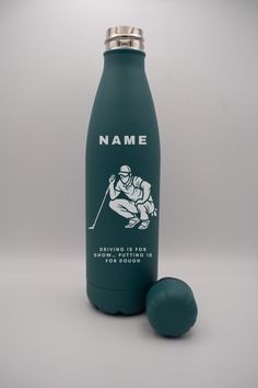 a green bottle with a silver lid next to a blue ball on a gray background