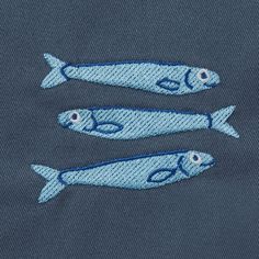 two blue fish embroidered on the back of a shirt