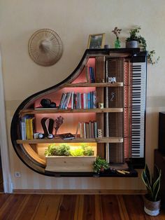 a piano shelf with books and plants on it