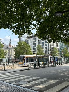 a public transit bus on a city street with tall buildings in the backround