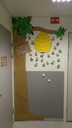 an office door decorated with paper decorations and stickers on the wall, including a beehive