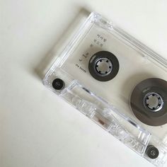 two black and white cassettes sitting on top of each other in a plastic case