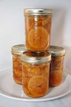 four jars filled with orange slices on a white plate