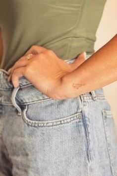 a person with a small tattoo on their left arm and the other hand in her pocket