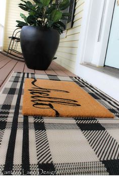 a black and white checkered rug on the front porch with a potted plant