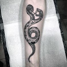 a black and white snake tattoo on the leg