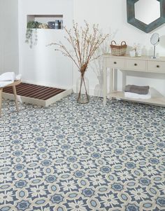 a bathroom with a blue and white tile flooring next to a wooden vanity table