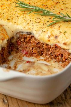 a casserole dish with meat and cheese in it on a wooden table top