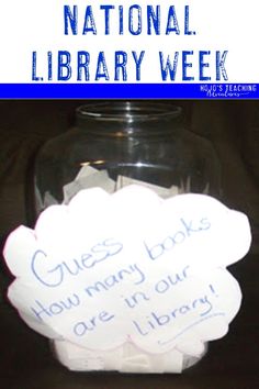 a glass jar filled with books and paper on top of a wooden table next to a blue sign that says national library week