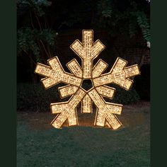 a lighted snowflake in the middle of a yard