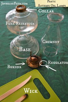 the parts of an antique oil lamp on a green tablecloth with labels and instructions