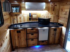 a kitchen with wooden walls and black counter tops