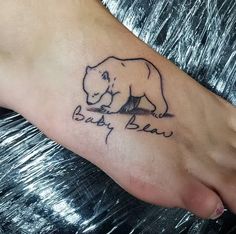 a small bear tattoo on the foot of a person