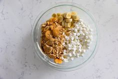 a bowl filled with cereal and marshmallows on top of a marble counter