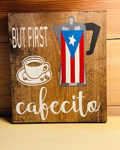 a wooden sign that says but first, cafecito with a coffee pot on it