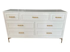 a white dresser with gold handles and drawers