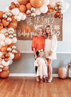 two women and a child standing in front of a sign