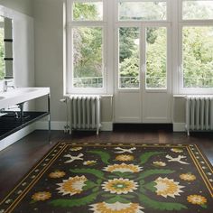 a large rug is in front of two windows and a radiator on the wall