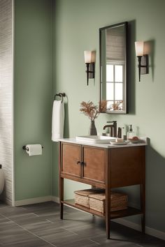 a bathroom with green walls and a wooden sink vanity next to a white towel dispenser