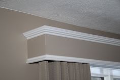 the corner of a room with a window and curtain valance on the wall above it