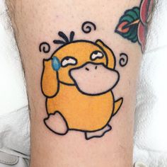 a cartoon tattoo on the leg of a person with a flower in front of him