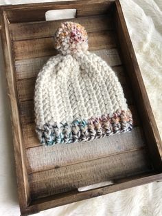 a crocheted hat in a wooden box