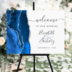 an easel with a sign that says welcome to our wedding