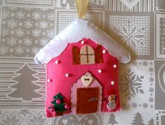 a felt house ornament hanging on a wall