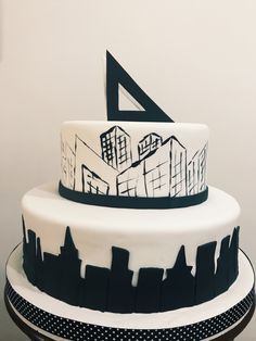 a three tiered cake decorated with black and white cityscape